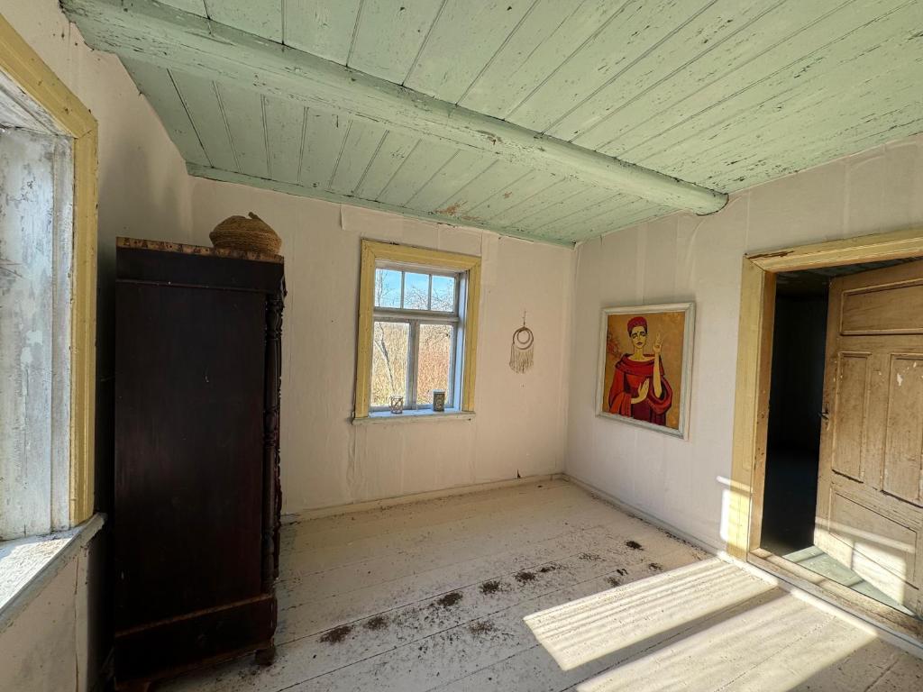 an empty room with a window in an old house at The White MEADOW in Titova