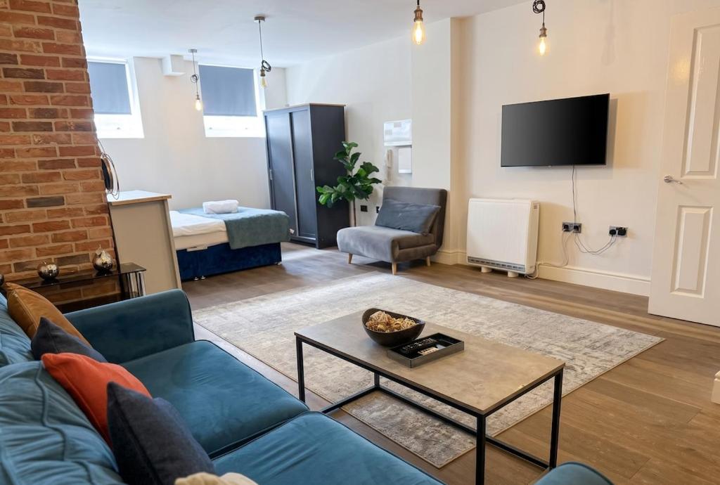 a living room with a blue couch and a table at Large central studio Sleep 3 in Brighton & Hove