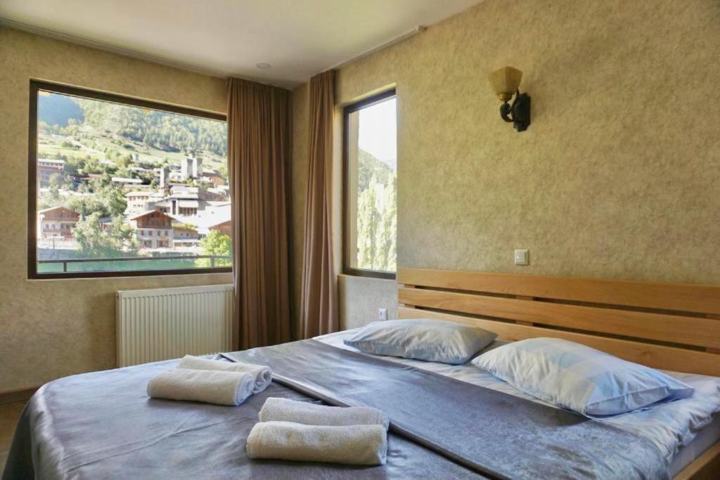 a bedroom with a bed with two towels on it at Mestia Panorama in Mestia