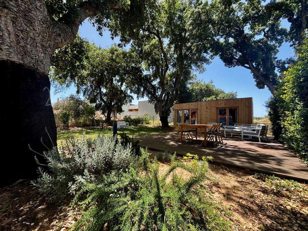 a cabin with a table and a bench under a tree at Encanto de Azeitão in Aldeia de Irmãos