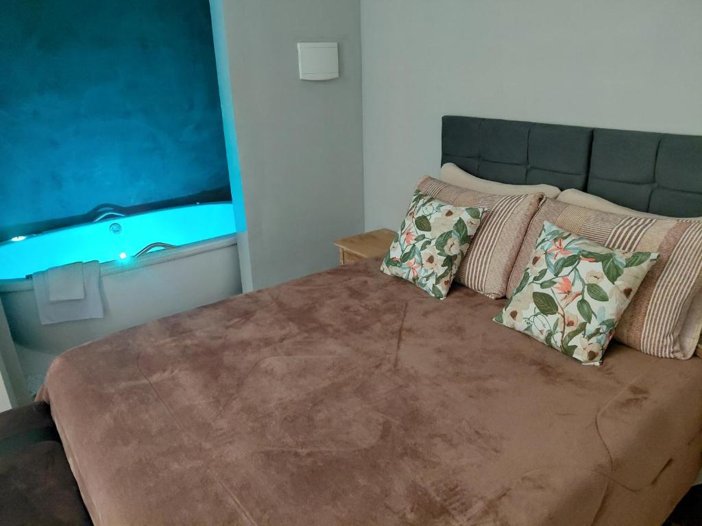 a bedroom with a bed with two pillows on it at Chalé Jaguary com hidro,Monte Verde MG in Companhia