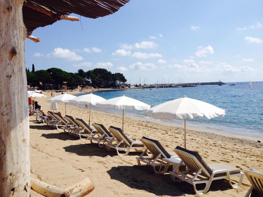 una fila de sillas y sombrillas en una playa en La Casa Mia en Sainte-Maxime