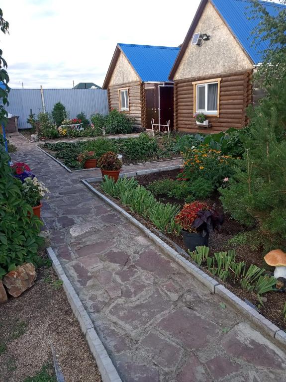 a garden with a house and some plants at Синие домики in Borovoye