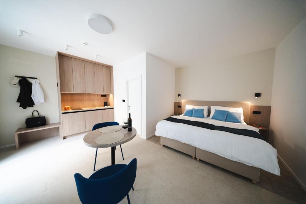a bedroom with a bed and a table and chairs at TWILL Apartments in Brno
