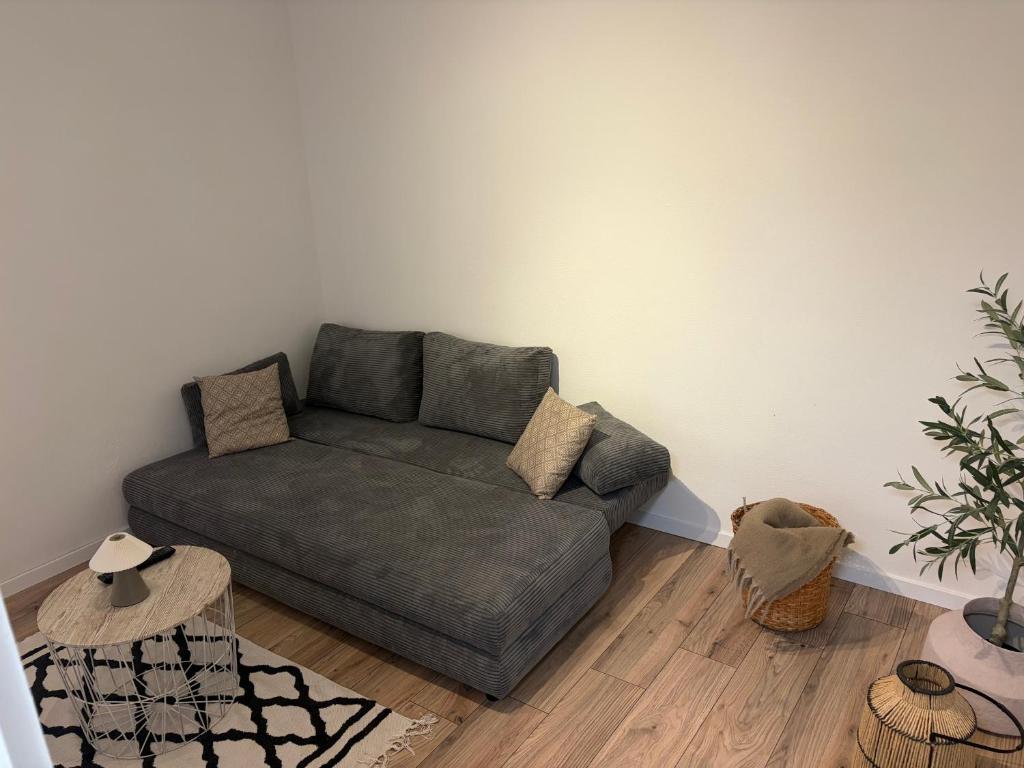a living room with a green couch in the corner at Ferienwohnung Elli in Haiterbach