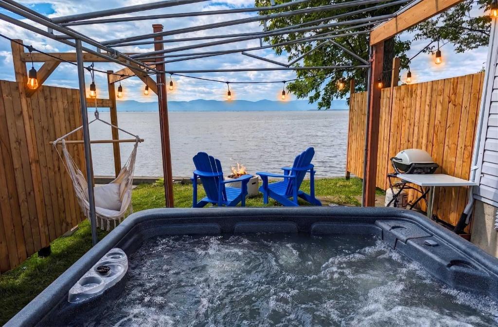 a hot tub on the side of a house next to the water at Chalet #10 - Spa & Fireplace in Cap-Saint-Ignace