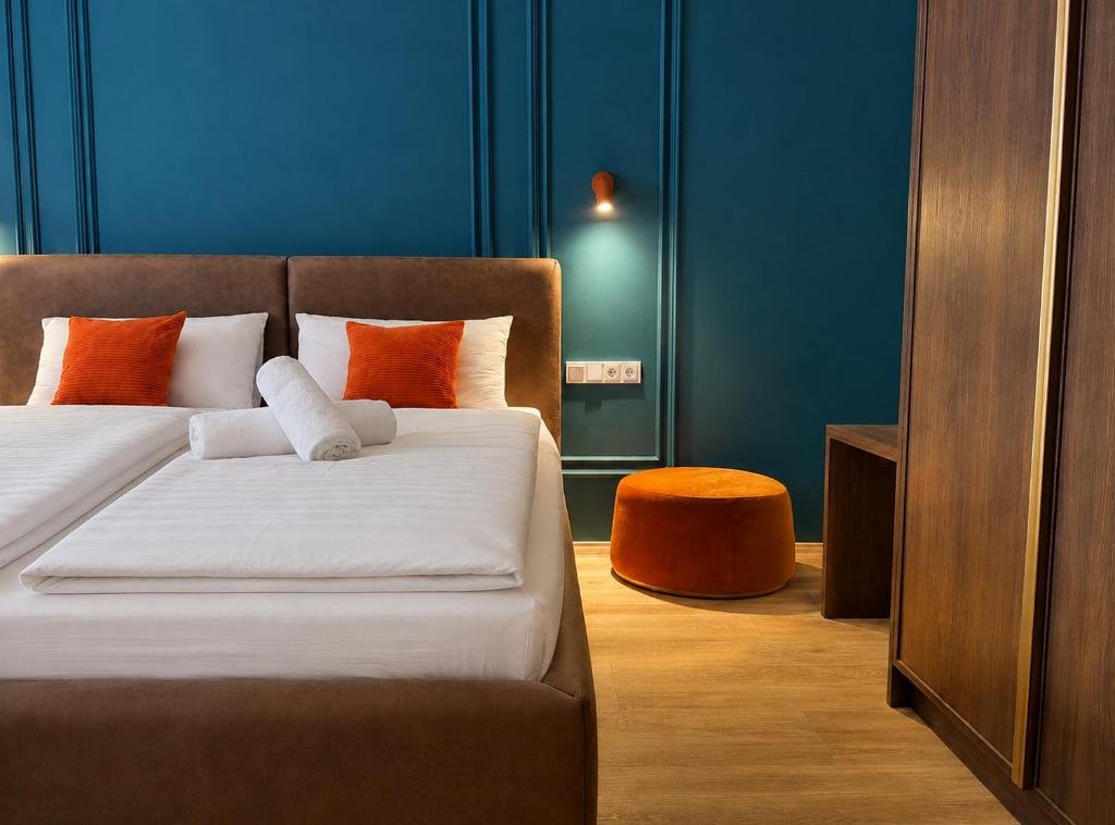 a bedroom with a bed with orange and blue walls at Hotel Nare in Boppard