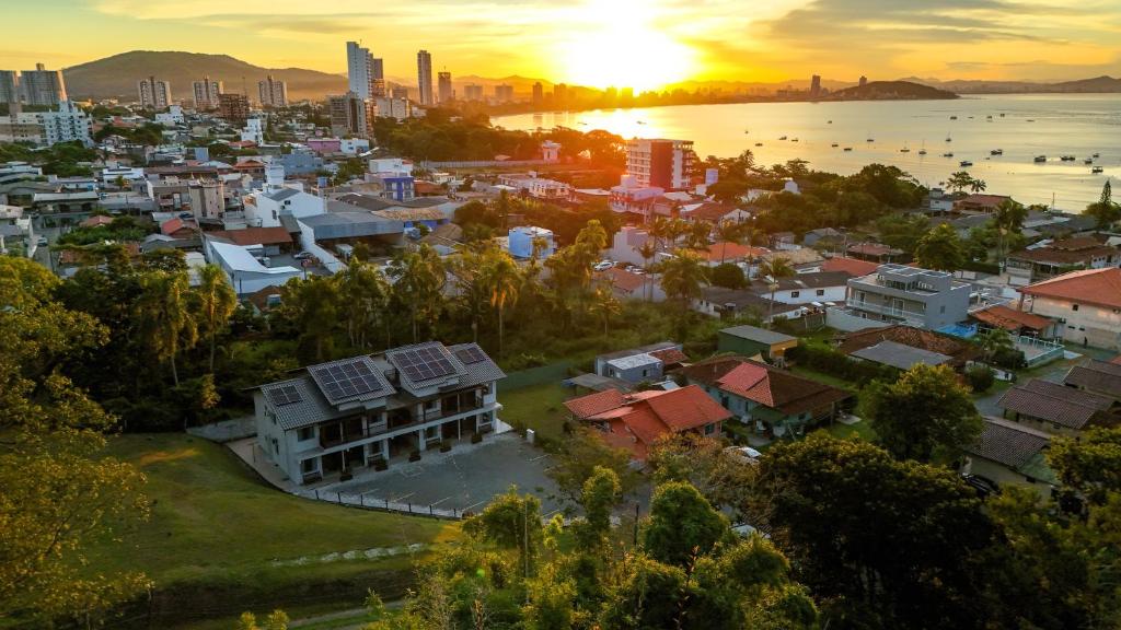 an aerial view of a city with the sun setting at Ipê Eco Village, Apartamentos perto do Beto Carrero in Penha