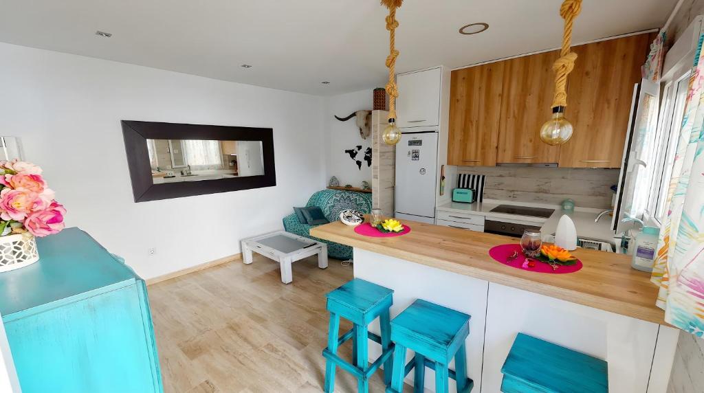 a kitchen and living room with blue stools at Apartamento Aguamarina con terraza in Chiclana de la Frontera