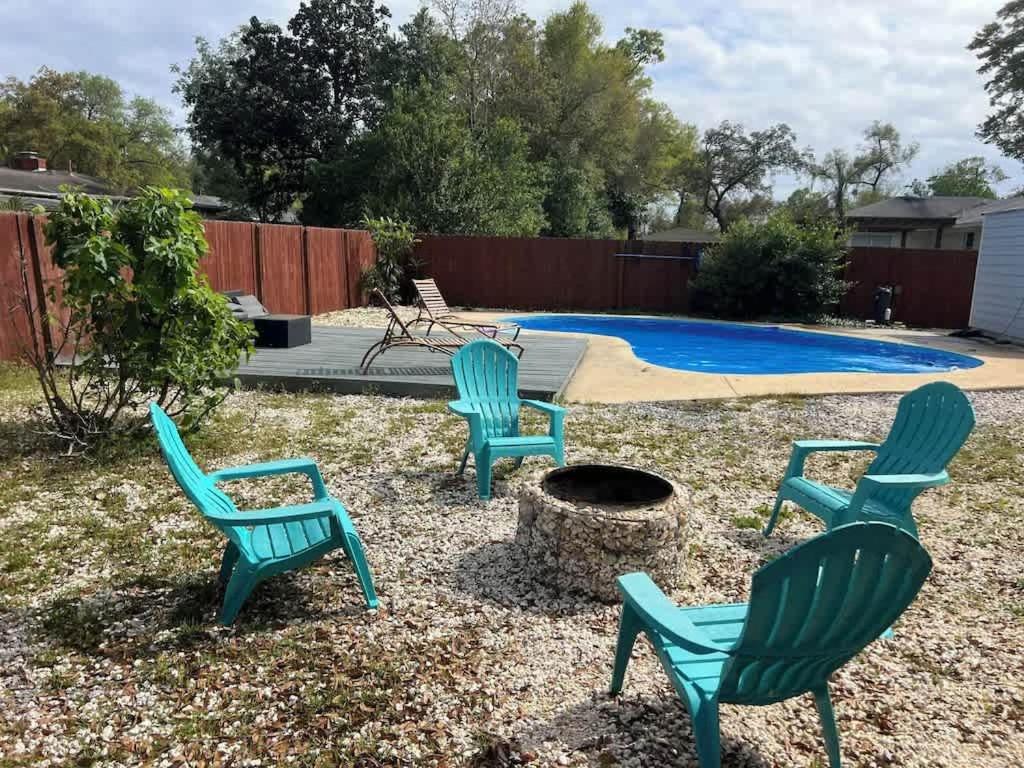 four green chairs in a yard with a pool at A Poolside Paradise in Pensacola