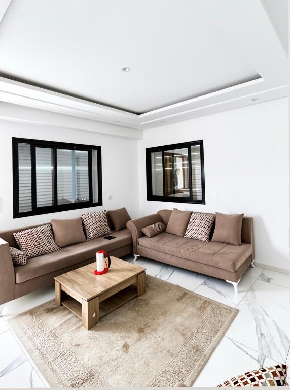 a living room with two couches and a coffee table at Pearl Beach Apartment in Monastir