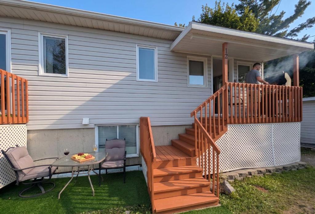 a man standing on the porch of a house at Chalet Studio #12 - Relaxing getaway with Wifi & AC in Cap-Saint-Ignace