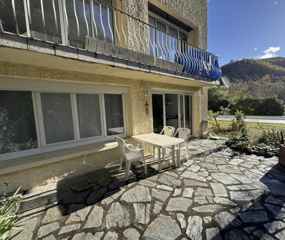 a patio with a table and chairs outside of a building at Logis PONIENTE in Arles-sur-Tech