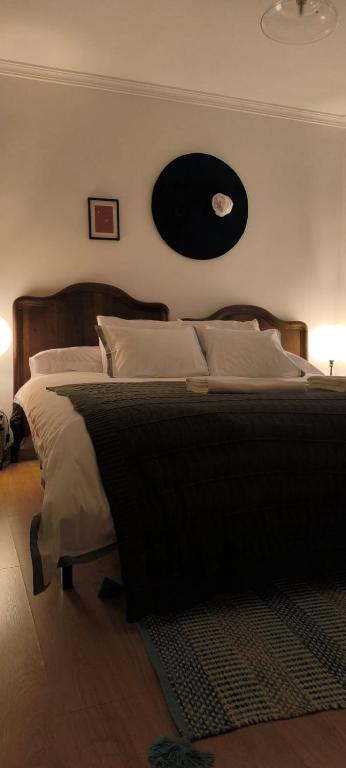 a bedroom with a large bed with a black record on the wall at Plantier Guesthouse in Figueira de Castelo Rodrigo