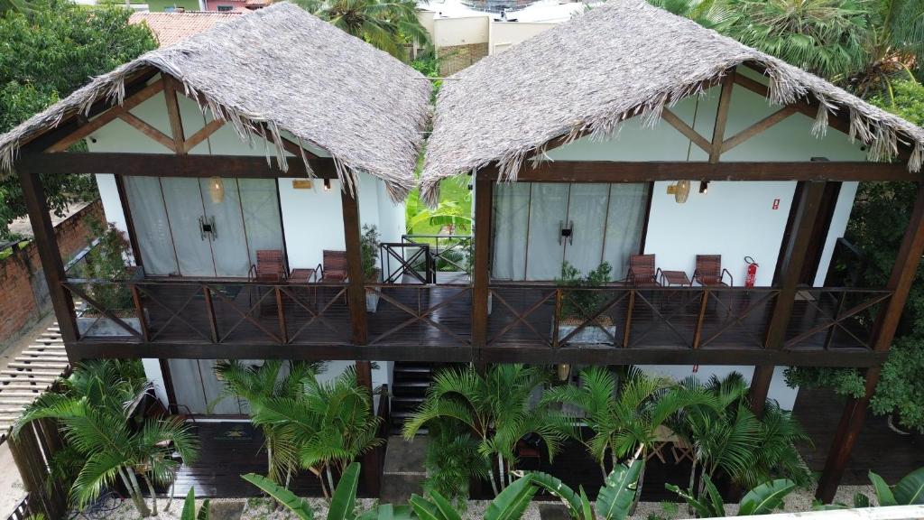 a resort with chairs and a thatched roof at Pousada Angelim in Santo Amaro