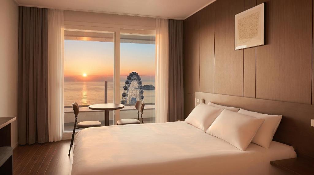 a hotel room with a bed and a view of the ocean at Le Collective Sokcho Beach in Sokcho