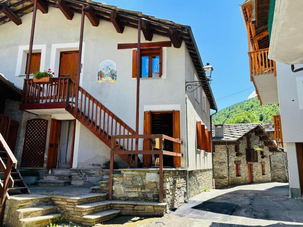 ein Haus mit Treppe und Balkon in der Unterkunft OmniViso in Crissolo