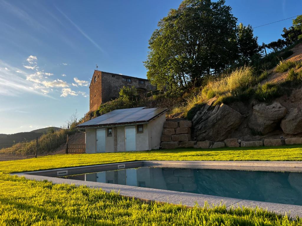 a swimming pool in the middle of a field with a building at Angrill in Lladurs
