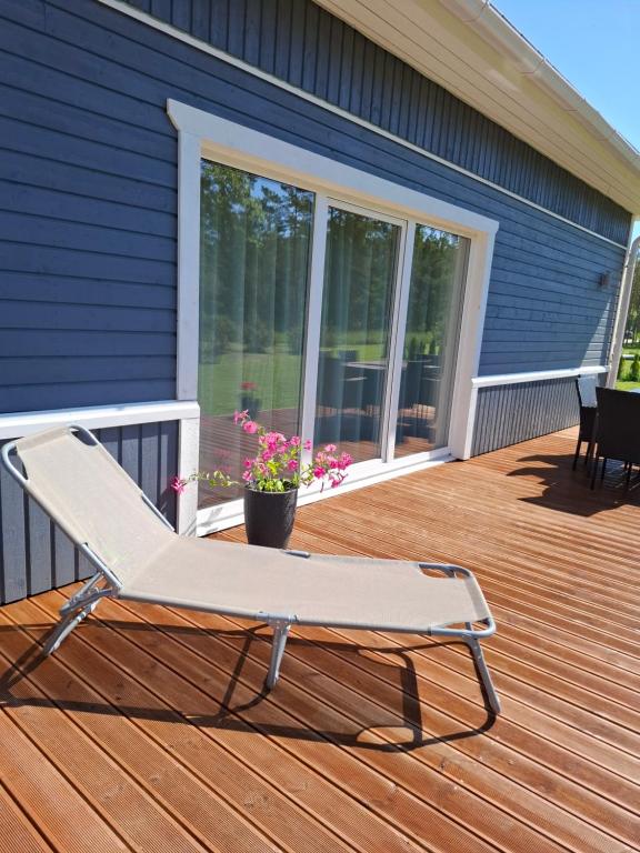 a deck with a chair on a house at Sõbra SPA Villa Haapsalu lähistel kaunis looduses in Nõmme