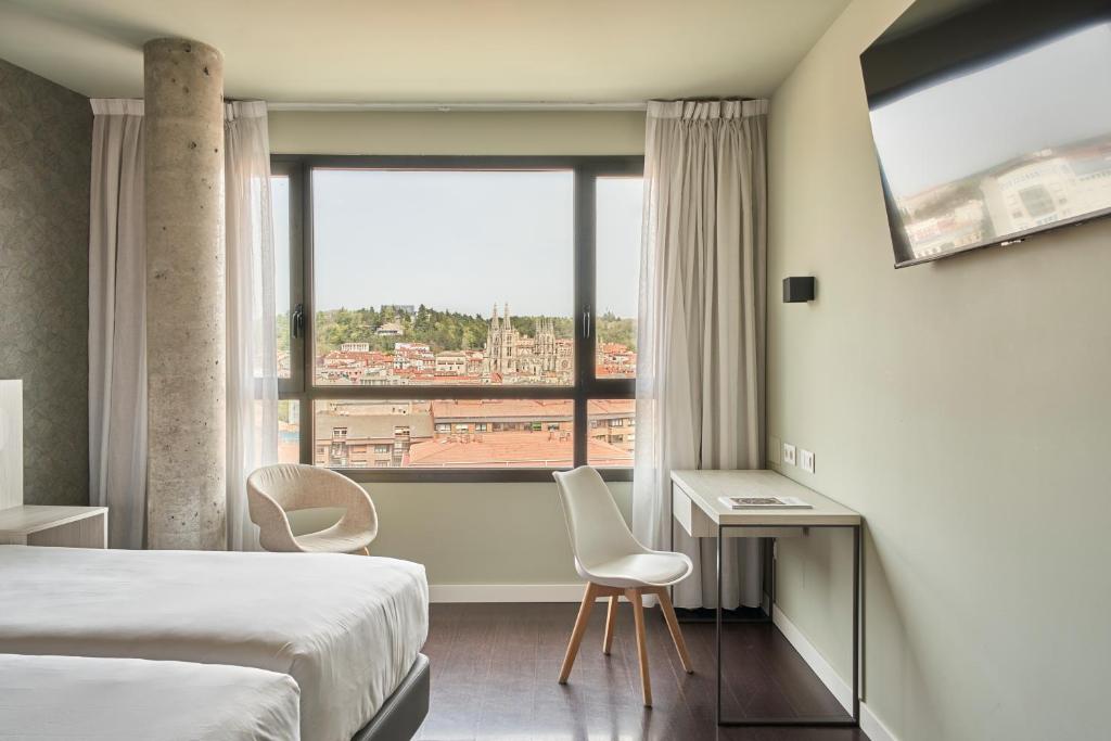 a hotel room with a bed and a large window at RICE Bulevar in Burgos