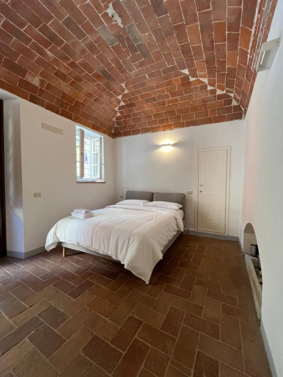 ein Schlafzimmer mit einem Bett mit einer Ziegeldecke in der Unterkunft Le volte in Seravezza