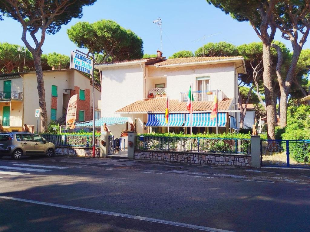 a building with a fence in front of a street at Albergo Tre Stelle in Marina di Grosseto