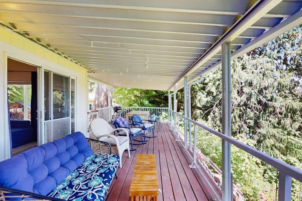 a porch with a blue couch and chairs at Hill House in Belfair