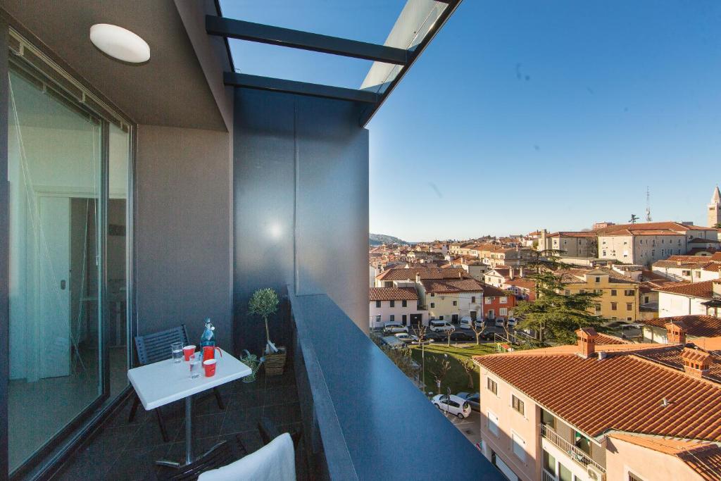 uma varanda com uma mesa e vista para a cidade em Hostel Villa Domus em Koper