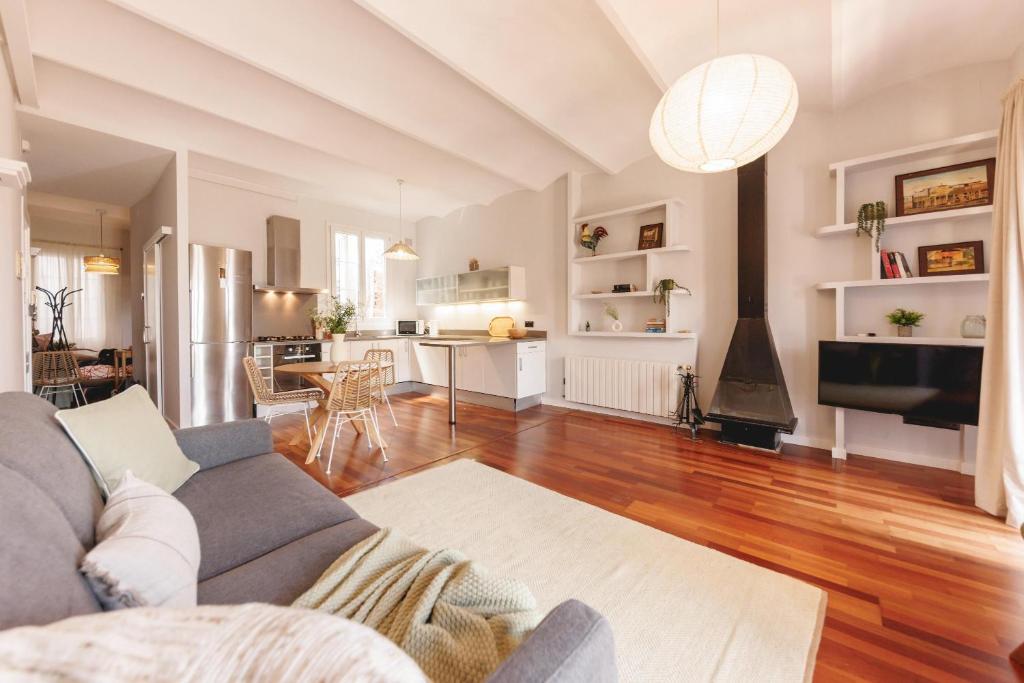a living room with a couch and a kitchen at Bravissimo Nou del Teatre, with panoramic views in Girona