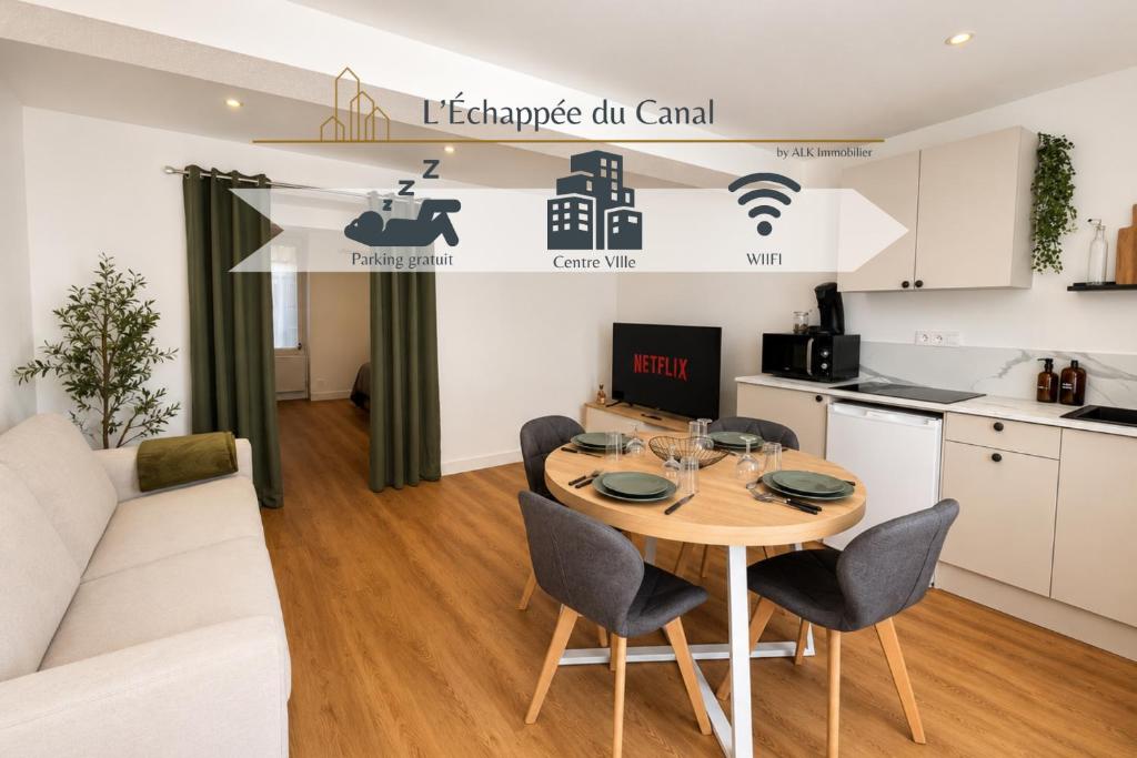 a kitchen and living room with a table and chairs at L'Échappée du Canal in Roanne