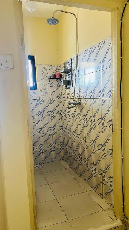 a bathroom with a shower with blue and white tiles at Spacious 2 bedroom Mtwapa in Mtwapa
