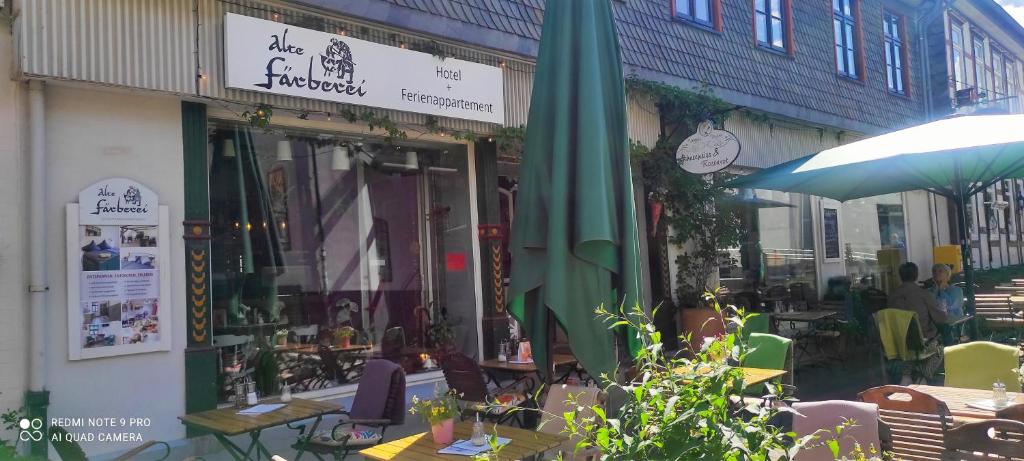a cafe with tables and umbrellas in front of a building at Hotel Alte Färberei in Goslar