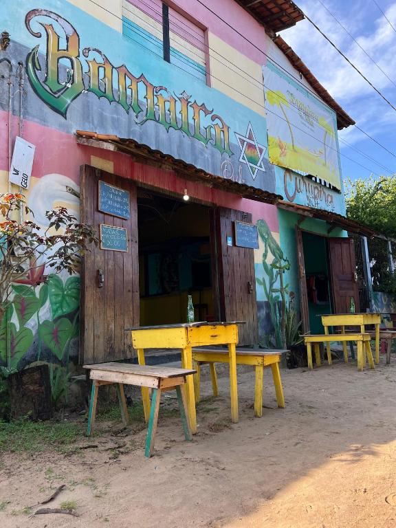 a yellow table and benches outside of a restaurant at Hostel Bamaica Algodoal - Espaço Curupira in Algodoal