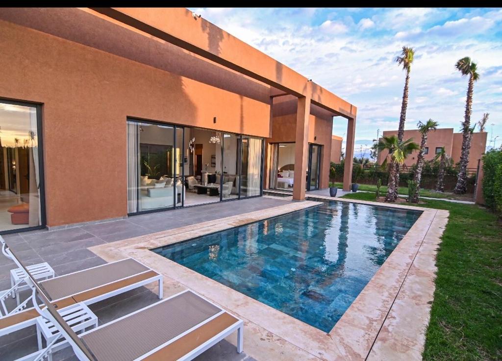 a house with a swimming pool in front of a house at The Oasis Marakech in Marrakesh