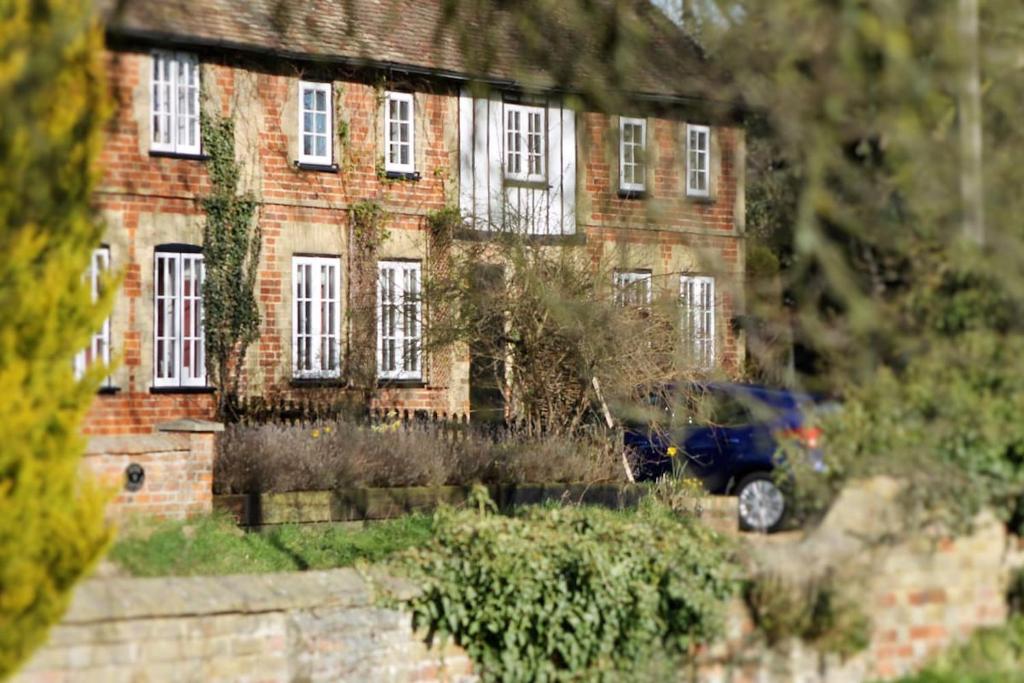 a brick house with a car parked in front of it at Number Eleven Unique Boutique in Great Gransden