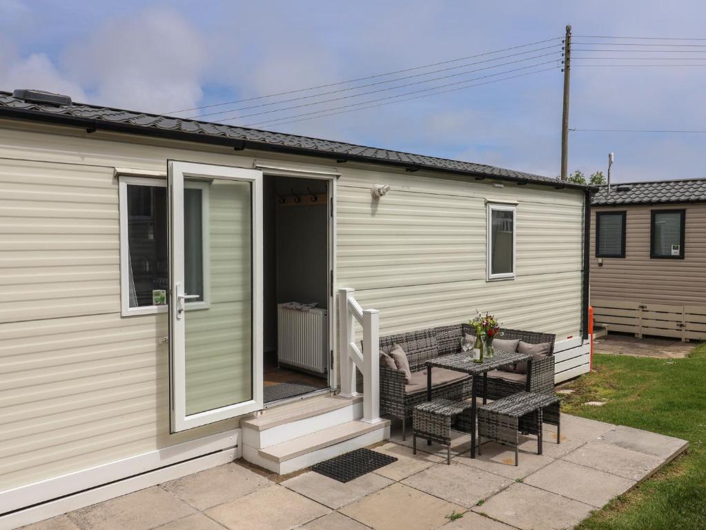 a mobile home with a patio and a table at Jurassic Discovery in Charmouth