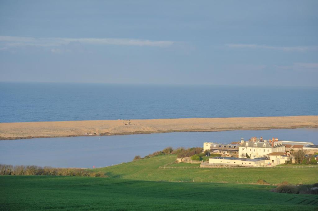 a large house on a hill next to a body of water at Moonfleet Manor Hotel in Weymouth