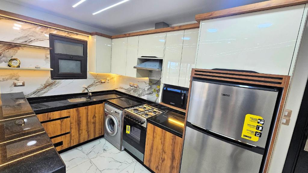 a kitchen with a stainless steel refrigerator and a dishwasher at 2bed rooms chalet portosaid in Port Said