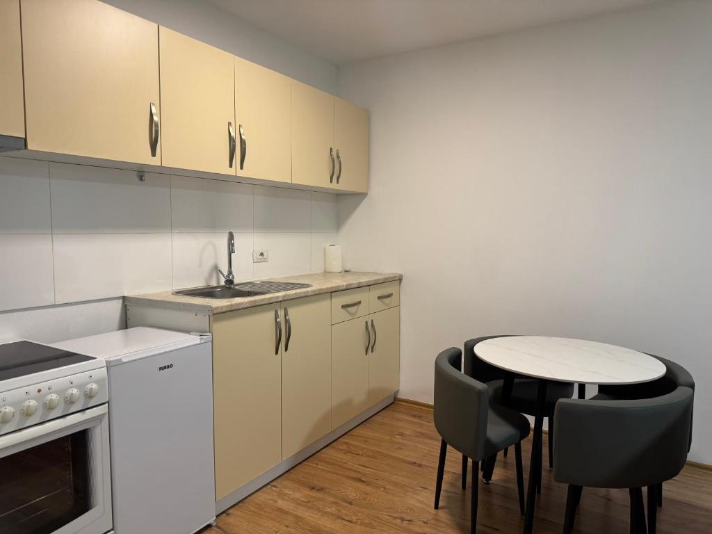 a kitchen with a small table and chairs at Fiona's apartment in Gjakove