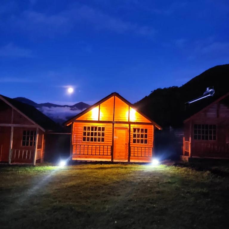 a cabin at night with the moon in the sky at San Marcos Mountain Lodge in Chontabamba