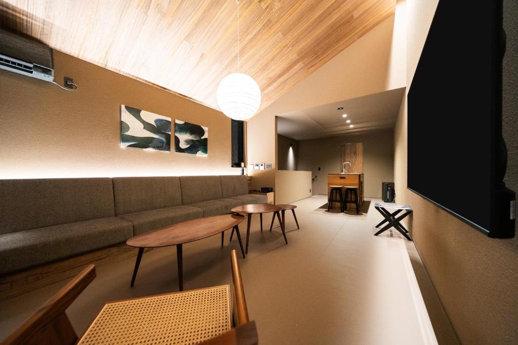 a living room with a couch and a table and chairs at Mon Hotel HAKATA in Fukuoka