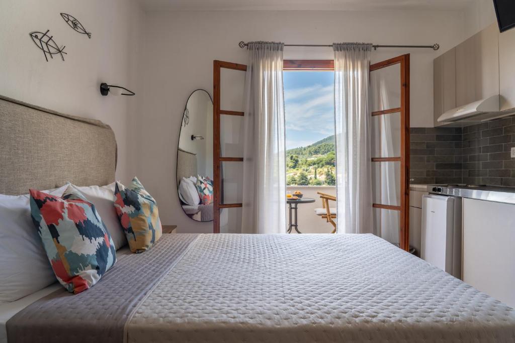 a bedroom with a bed with a view at Jimmy's Guest House Skiathos in Skiathos