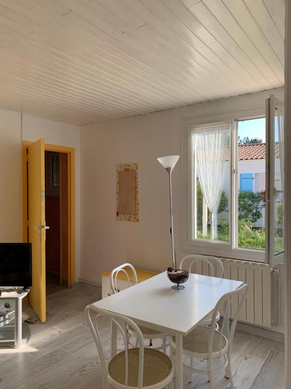 a dining room with a white table and chairs at Lascar in Royan
