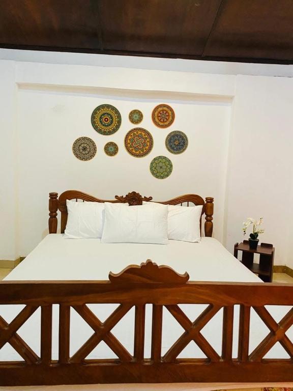 a bedroom with a bed with plates on the wall at Orchid Resort in Medawachchiya