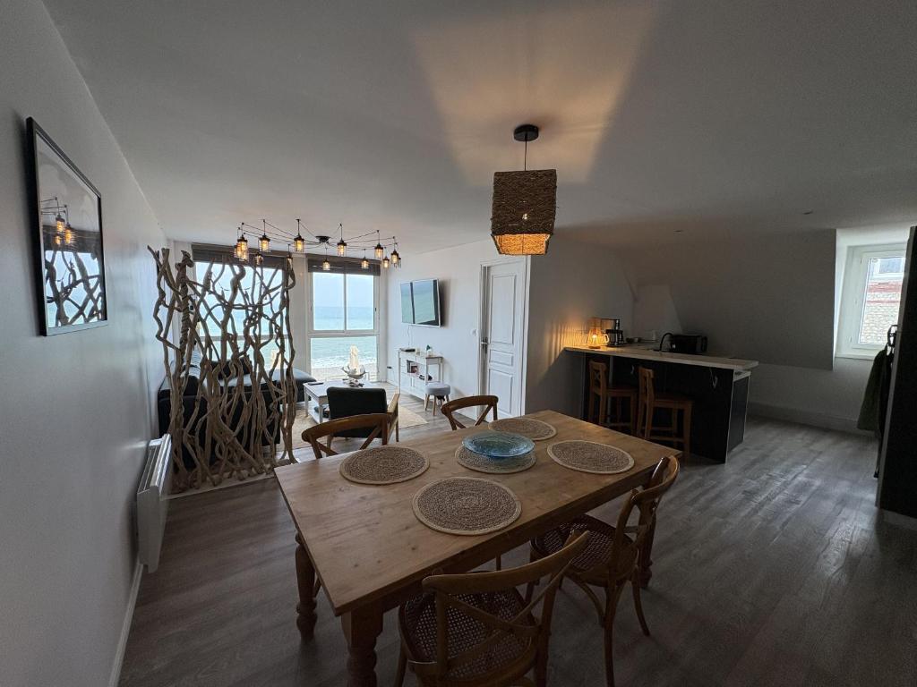 a living room with a wooden table and chairs at Le Sunset Beach (les pieds dans l'eau) vue mer exceptionnelle in Fécamp