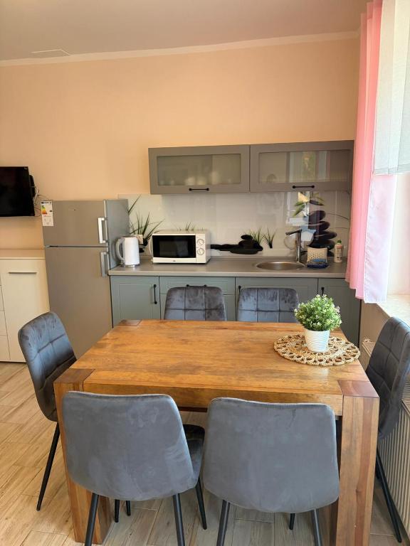 a kitchen with a table and chairs and a kitchen with a refrigerator at Pokoje ALbert UL GDAŃSKA 40 in Krynica Morska