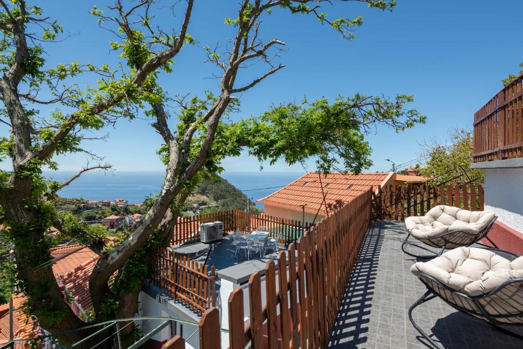 a balcony with chairs and a view of the ocean at Casa do Castanheiro in Campanário