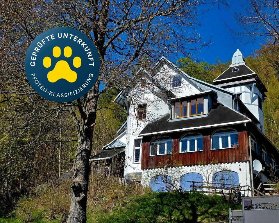 a large house with a paw sign in front of it at Ferienwohnung Feenblick in Kurort Altenberg