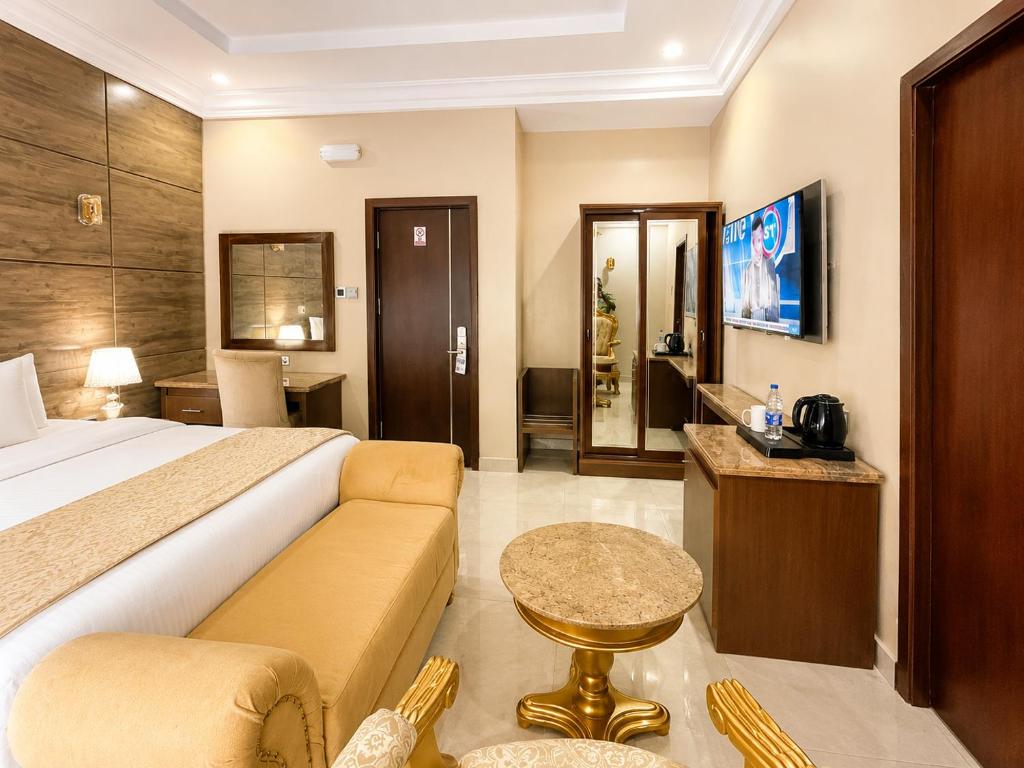 a hotel room with a bed and a couch at Grand Bohabs Hotel in Abuja