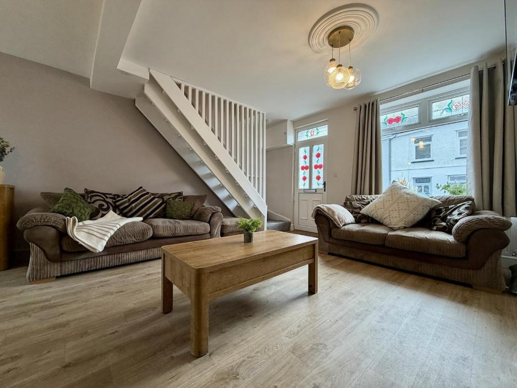 a living room with two couches and a coffee table at Hazel, Spacious 3-Bed Home in Dowlais